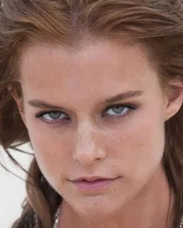 Kim Cloutier poses on the beach with her hair in a messy up-do.